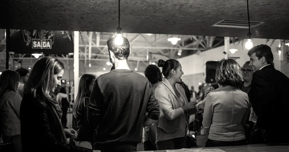 A lively indoor social gathering with people interacting warmly under cozy lighting.
