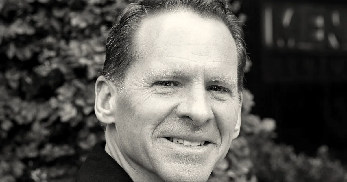Portrait of Matt Murphy, partner at Menlo Ventures, smiling in front of green foliage.