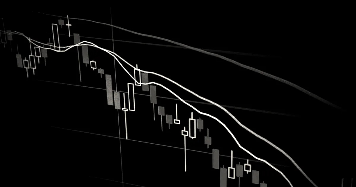 Close-up of a downward-trending financial candlestick chart displayed on a dark computer monitor.