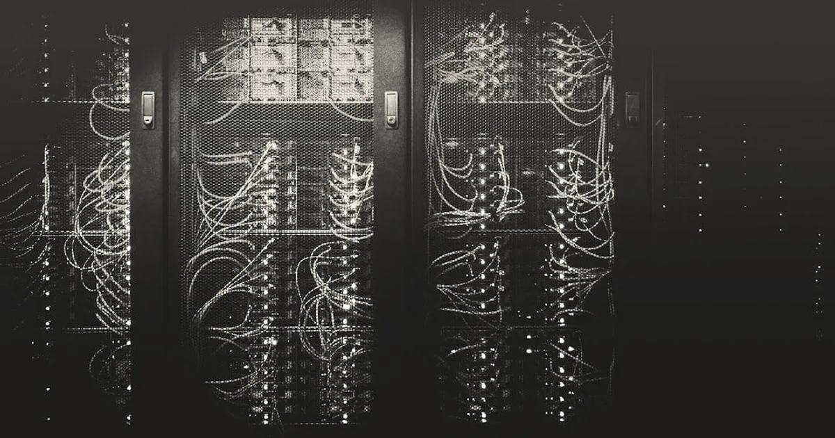A dark server rack filled with networked hardware and neatly routed colored cables.
