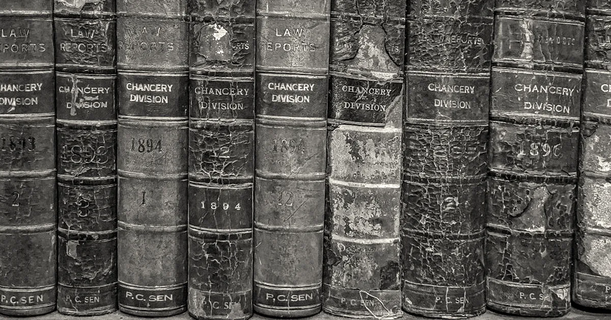 Row of vintage leather-bound legal report volumes featuring embossed gold lettering on weathered spines.