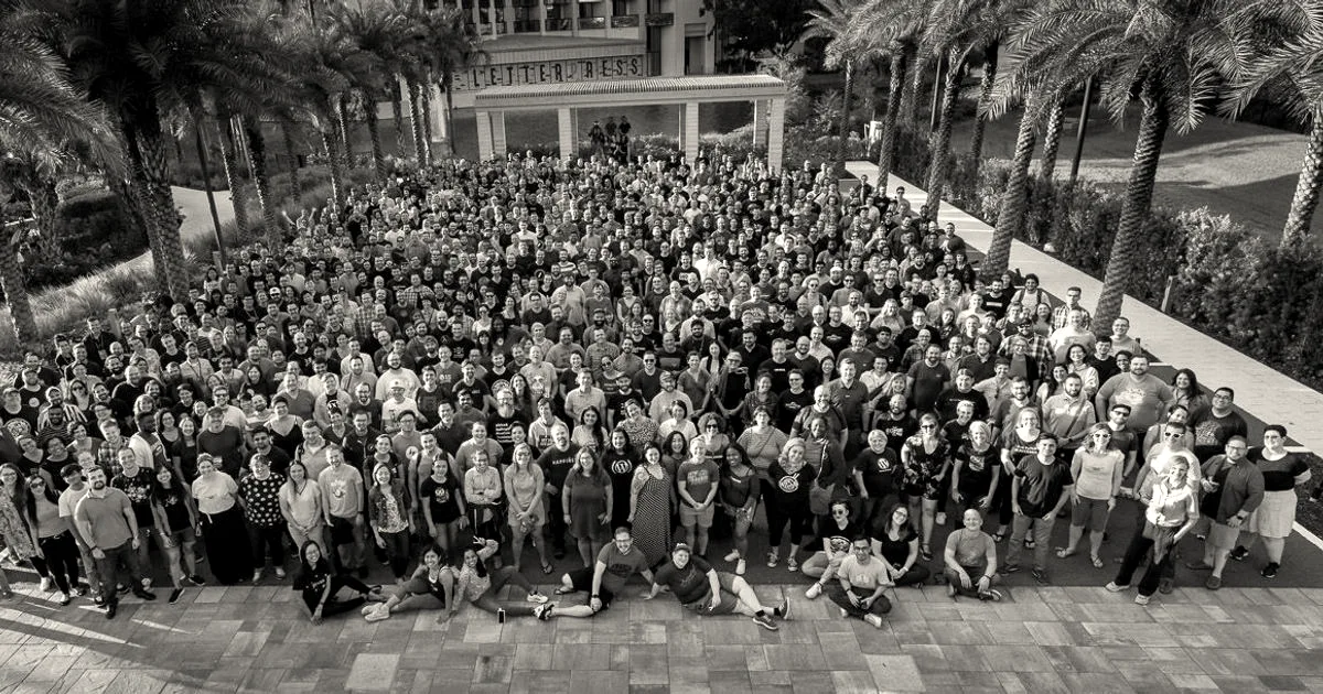 A large outdoor group photograph of hundreds of Automattic employees gathered together at a company event.
