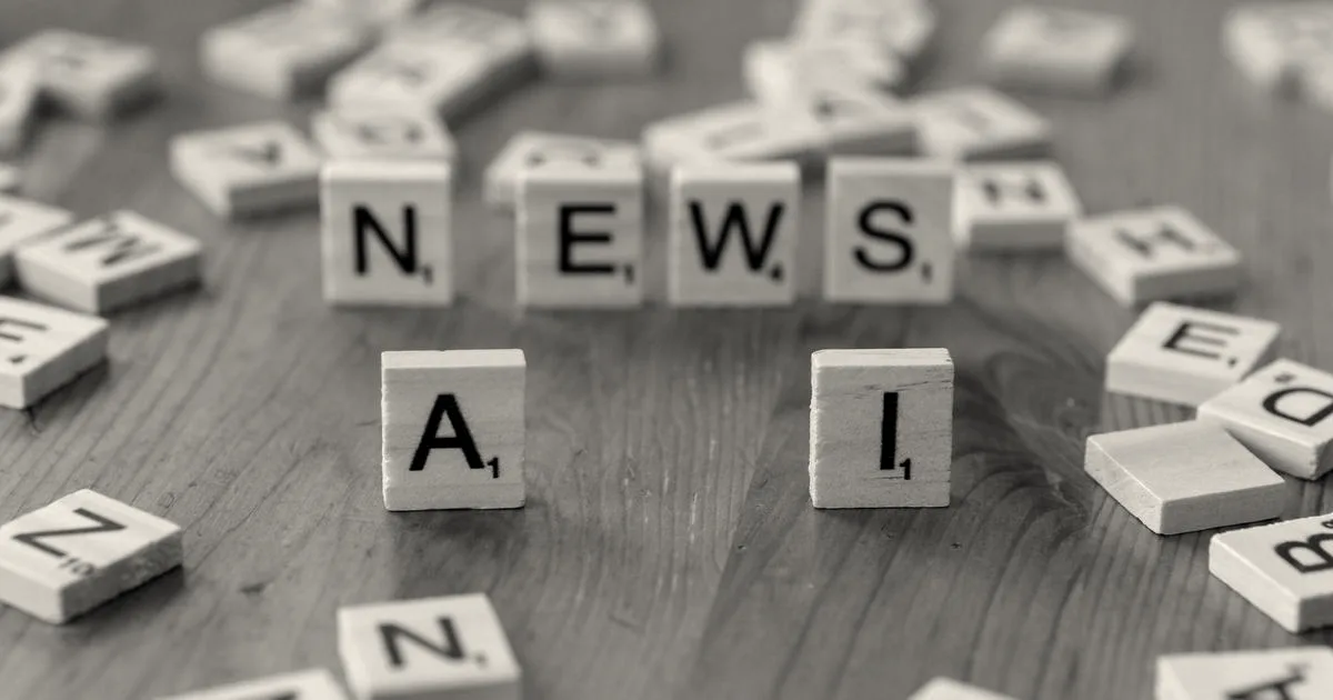 Wooden letter tiles spelling AI and NEWS on a wooden table surface surrounded by scattered letters.