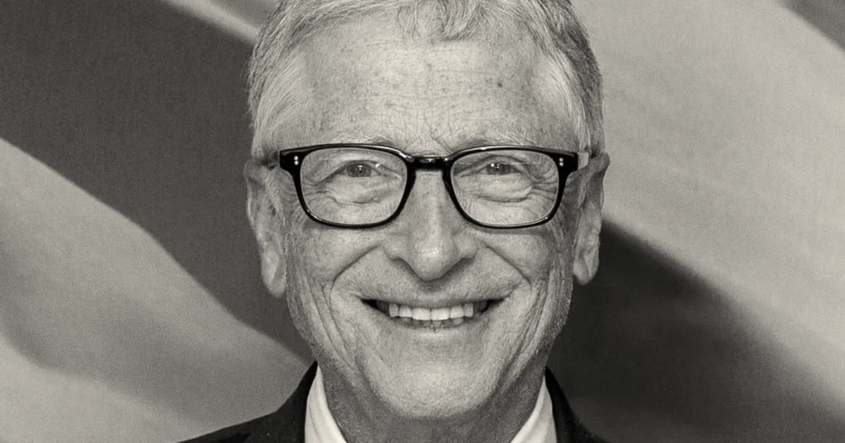 Bill Gates smiling while wearing glasses, a dark suit jacket, and a striped tie.