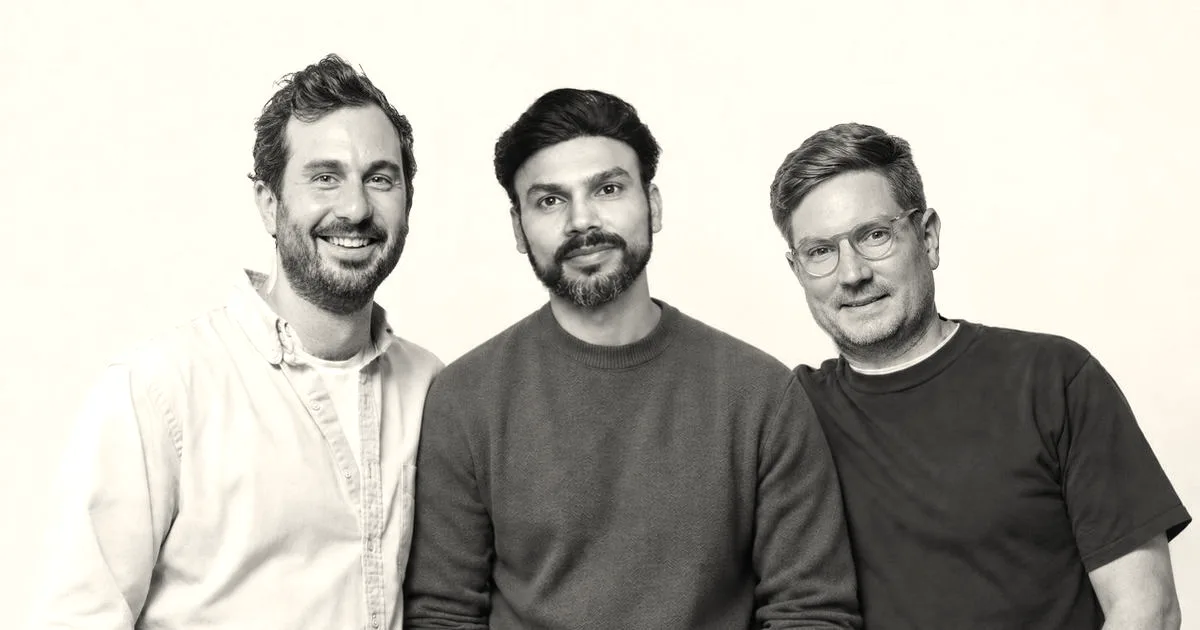 Three co-founders of Bloom standing side by side smiling against a plain light blue background.