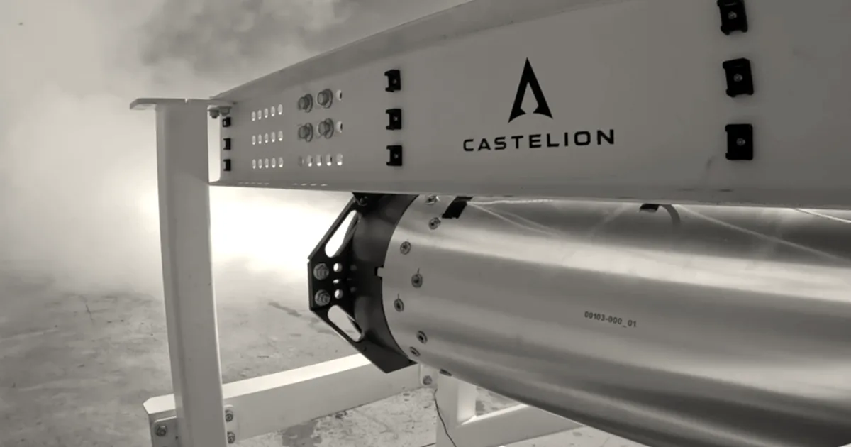 A Castelion rocket motor undergoing a static fire test on an outdoor test stand.
