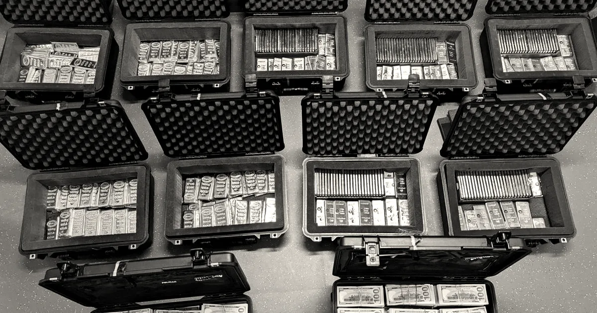 Open Pelican cases filled with rows of gold bars and stacks of hundred-dollar bills.