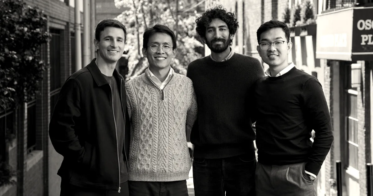 Four Corridor team members smiling together while standing outside on a brick-lined city street.