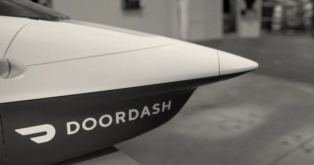 Close-up side view of a white and red DoorDash drone aircraft nose featuring the company logo.
