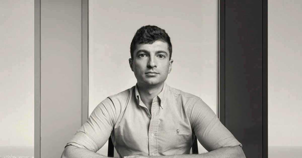 Dvir Ginzburg, founder and CEO of Encore AI, seated at a conference table in front of high-rise windows.