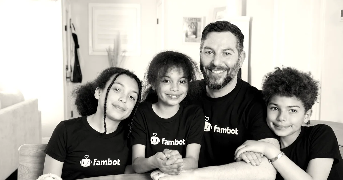 Fambot CEO David Reich sitting at a wooden table with his three children, all wearing black Fambot t-shirts.