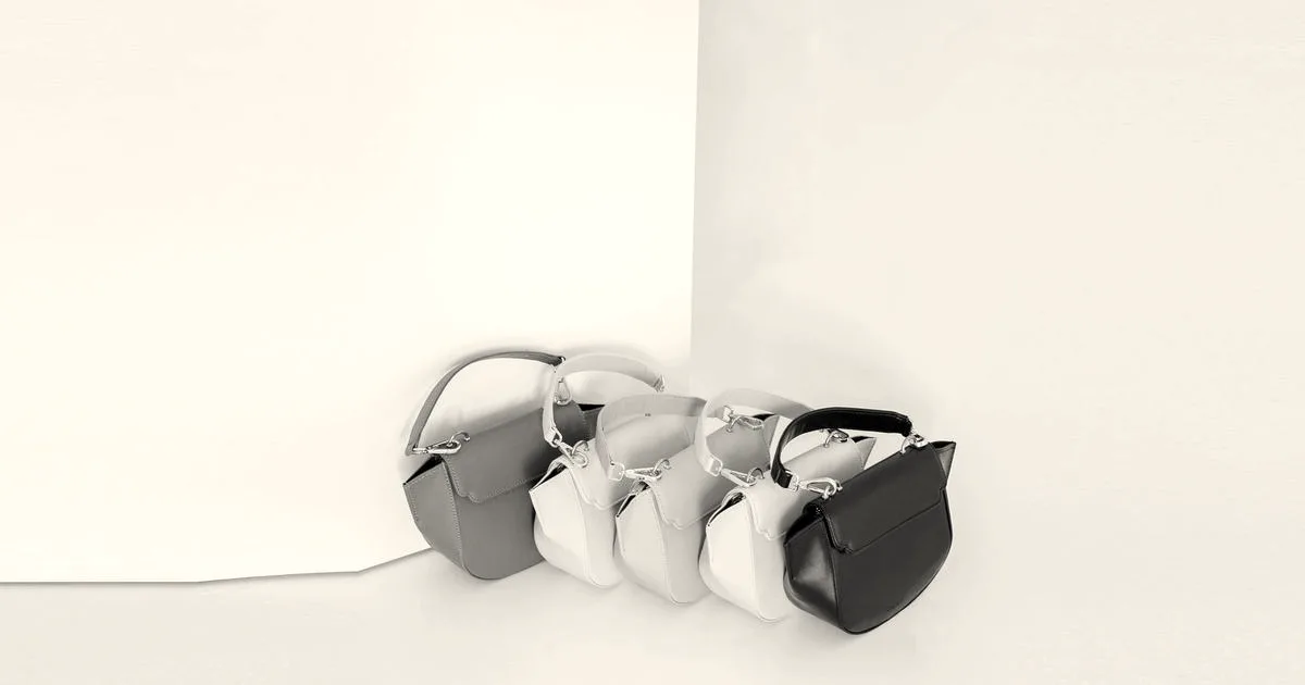 An assortment of minimalist pastel handbags arranged in a row against a clean white backdrop.
