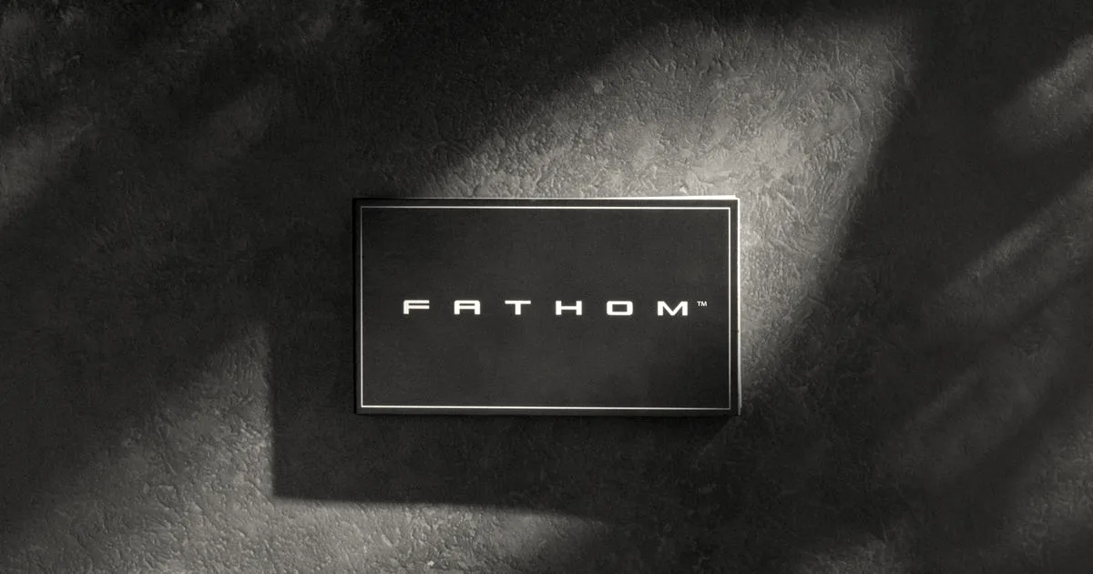 A black badge featuring the word Fathom in modern block lettering on a textured surface.