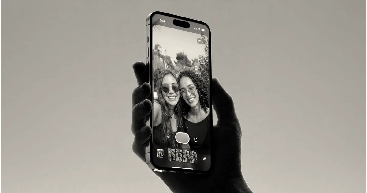 A hand holding a smartphone displaying the Superpose camera app with two women posing on screen.