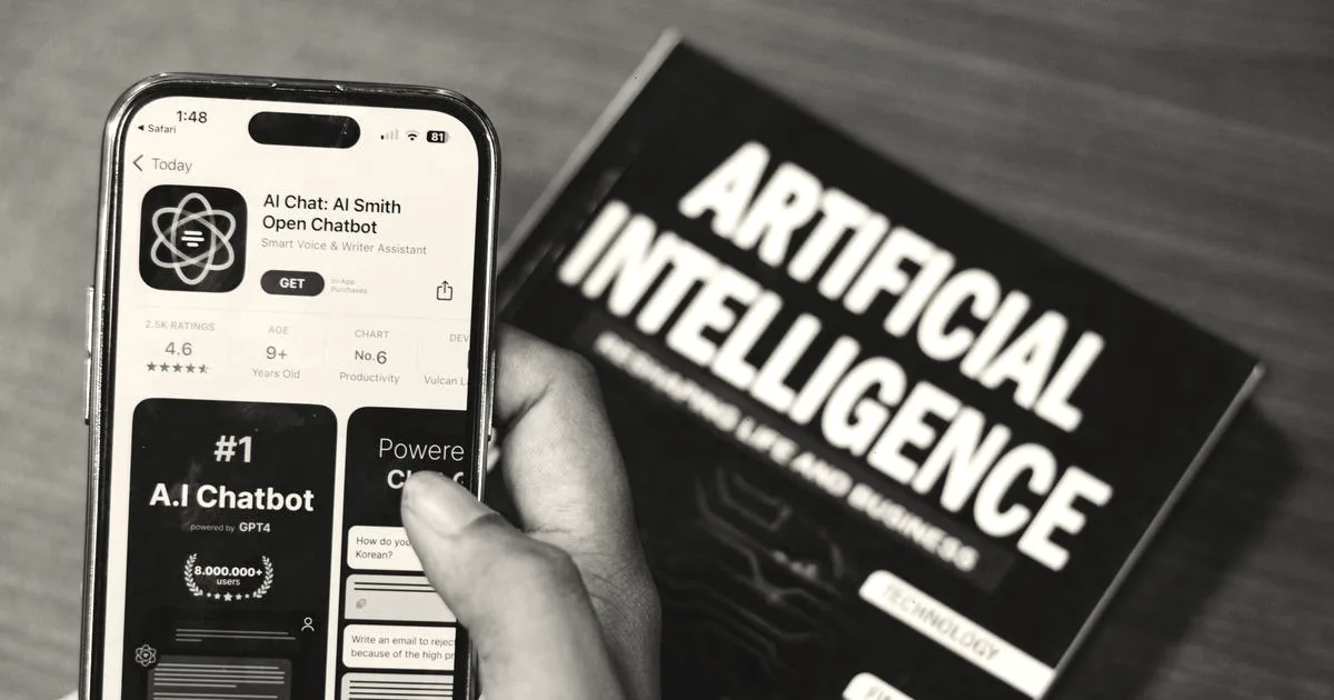 Smartphone displaying AI app with book on AI technology in background.