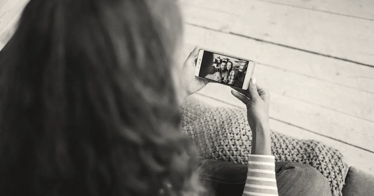 Happy girl is making video call with smartphone talking to friends online looking at screen and enjoying modern communication. Technology, young people and home concept.