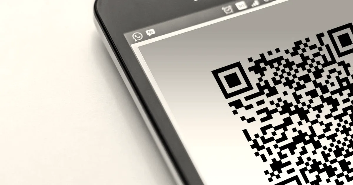 High-resolution close-up of a smartphone displaying a QR code on its screen.