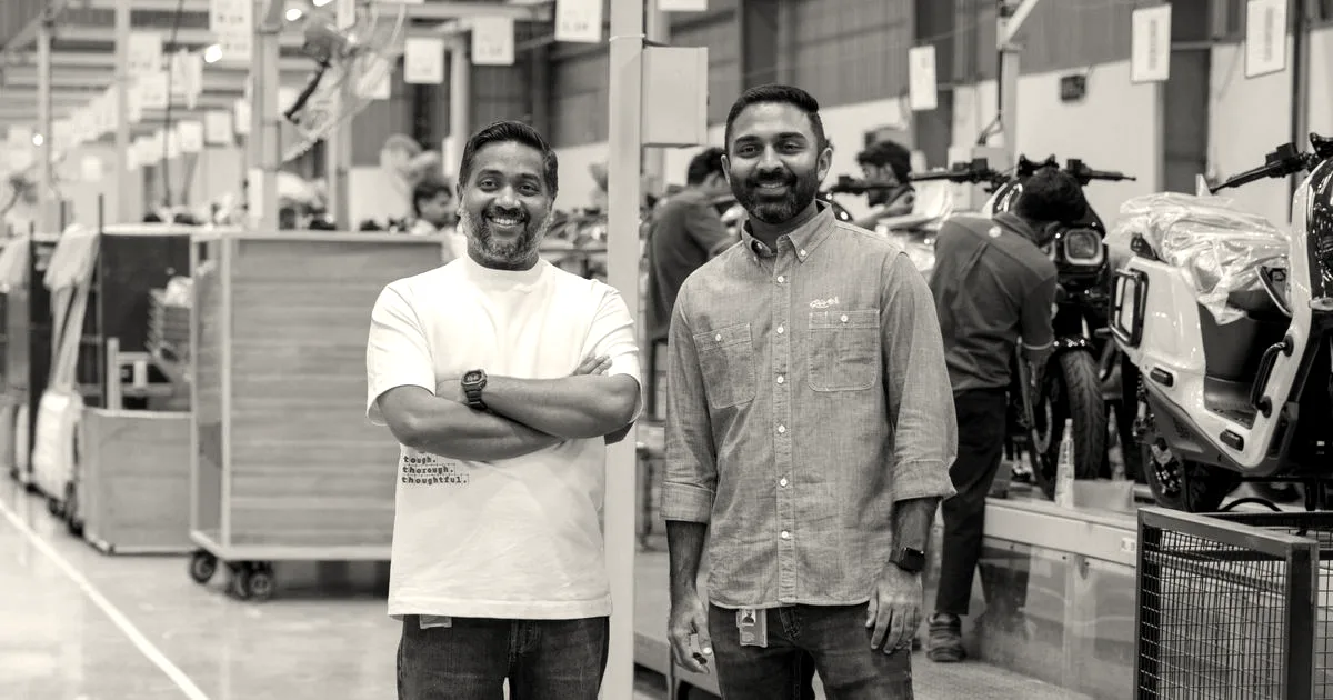River co-founders Aravind Mani and Vipin George smiling on their electric scooter manufacturing floor.