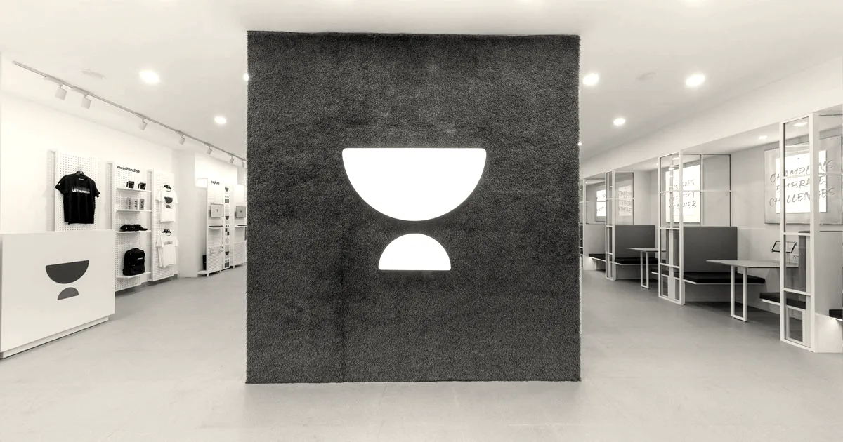 An Unacademy center lobby featuring a green moss wall with the company's white crescent logo.