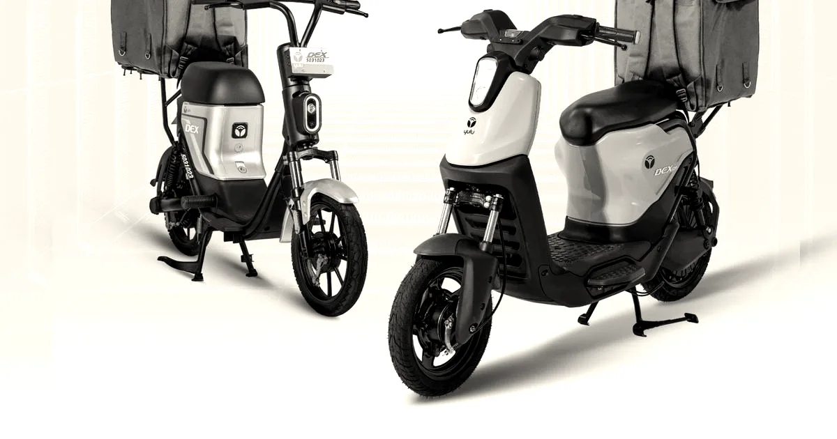 Two Yulu electric delivery scooters with blue delivery bags mounted on their rear racks.