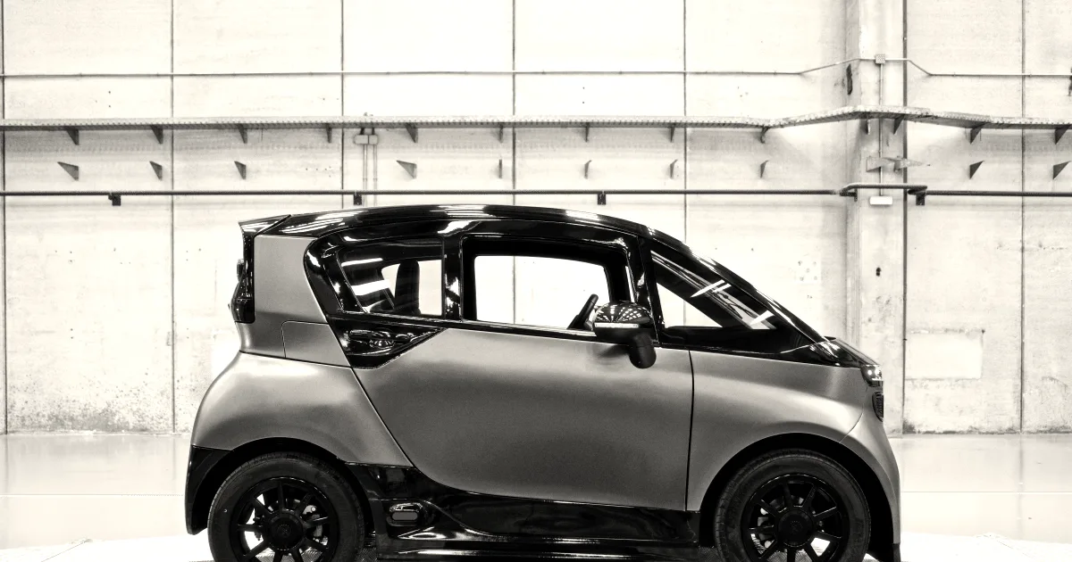 Side view of the Liux Big electric microcar inside a factory facility on a platform