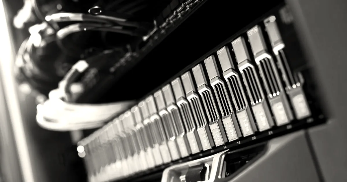 Close-up view of a blue lit server rack with hard drive bays and indicator lights.