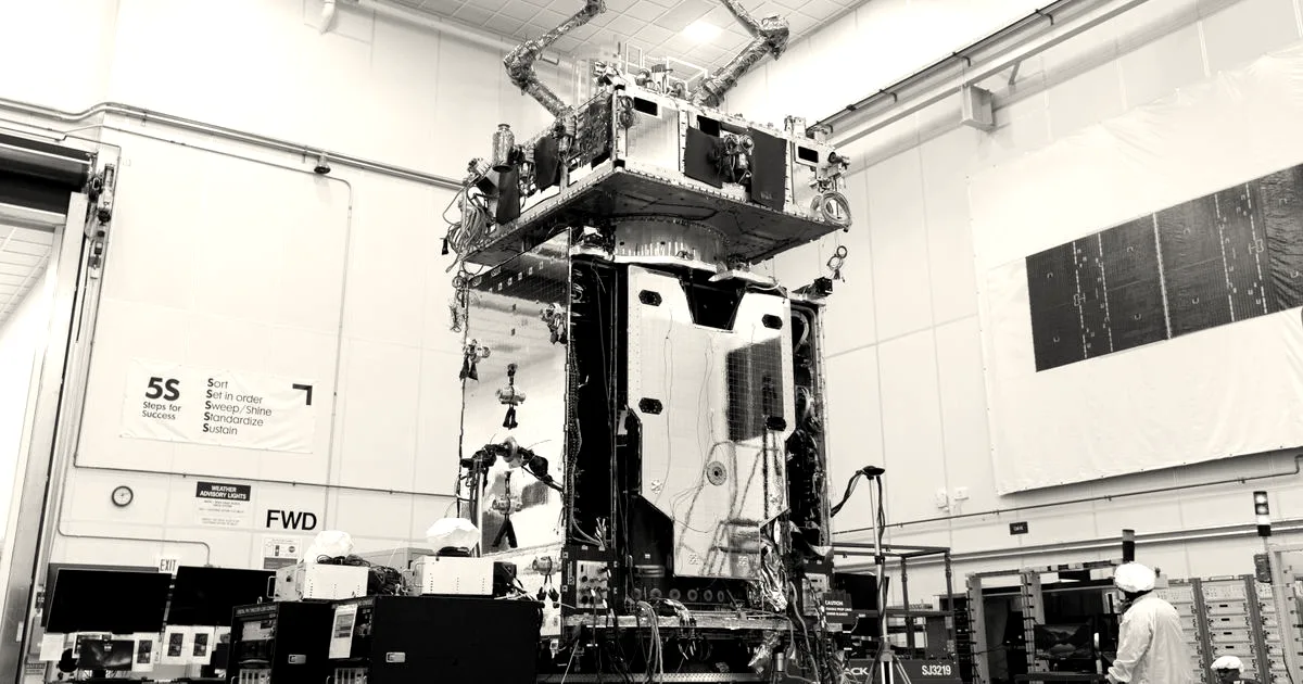 Northrop Grumman's Mission Robotic Vehicle satellite with extended robotic arms inside a clean room facility