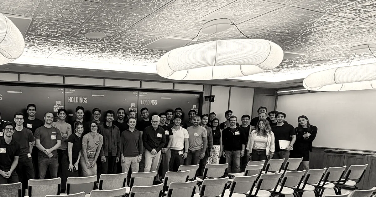 A large team gathered together in a modern conference room posing for a group photograph.