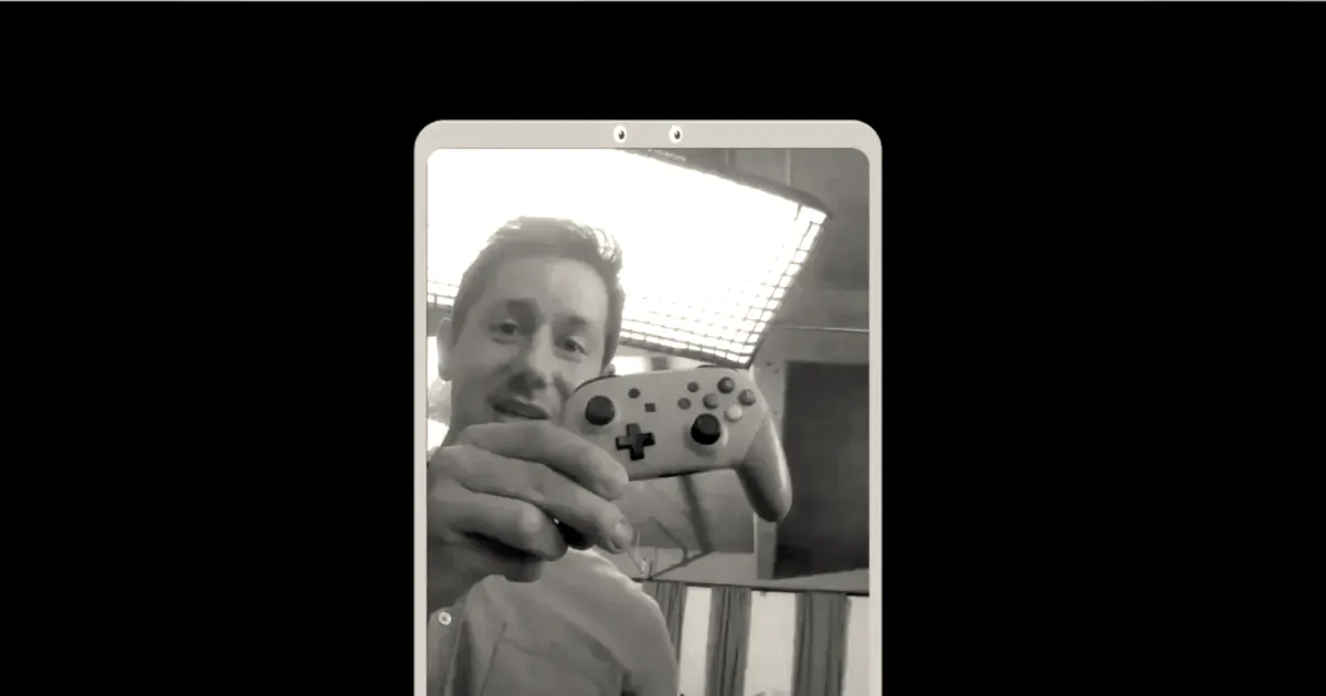 A person holding up a game controller and a green apple during a video demonstration.