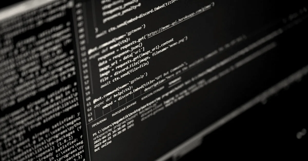 Close-up of a computer monitor displaying colorful code against a dark background.