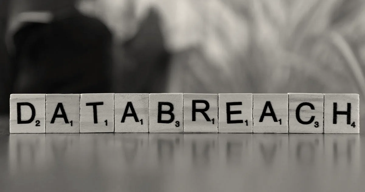 Scrabble tiles on a table spelling out the words DATA BREACH in block letters.