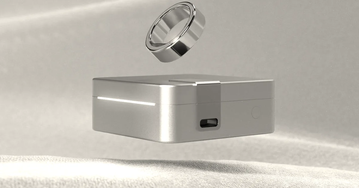 A gold Ultrahuman smart ring hovering above its square gold charging case.