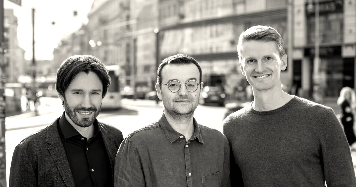 Three male co-founders of Restate standing outdoors on a city street smiling at the camera