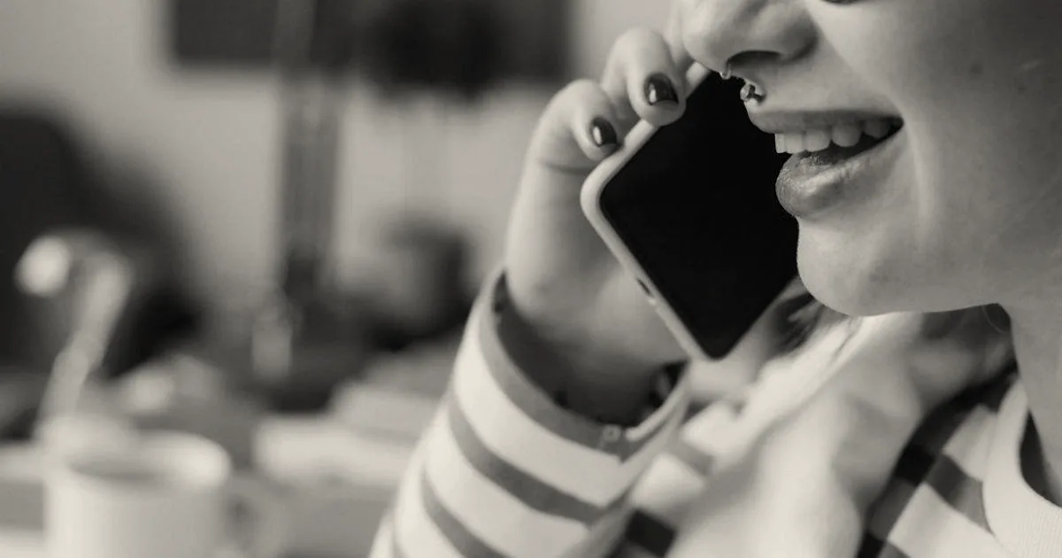 A woman talking on a cell phone with a smile on her face