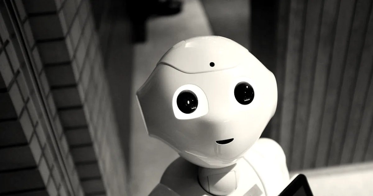 Close-up of a white humanoid robot with large dark expressive eyes looking slightly upward.