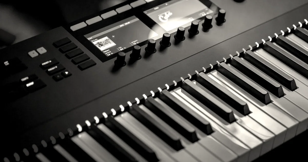 Close-up of an electronic keyboard with colorful illuminated keys in a studio setting.