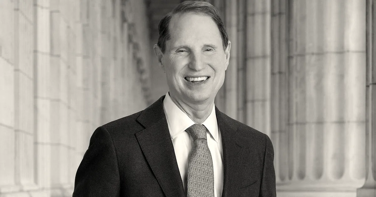 Portrait of Senator Ron Wyden smiling in a blue suit with a blue patterned tie.