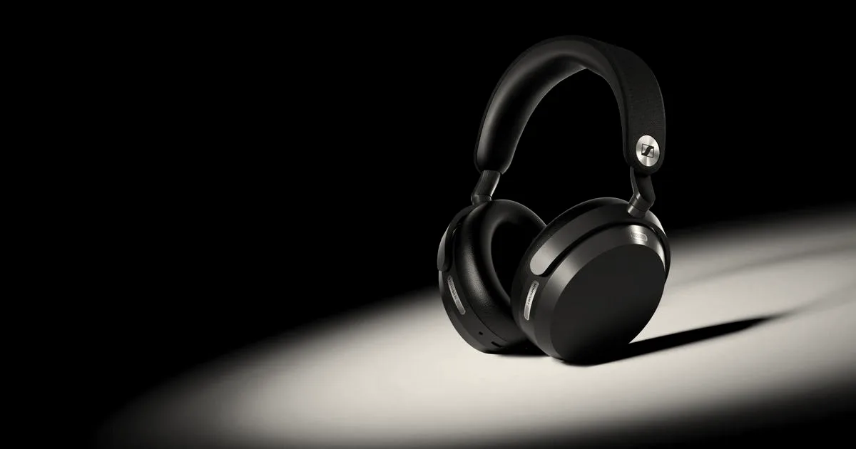 Black Sennheiser wireless over-ear headphones illuminated against a dark blue background