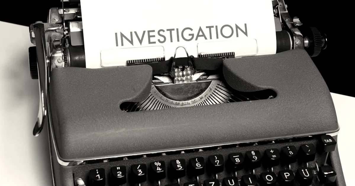 A vintage typewriter with a piece of paper loaded in it bearing the word INVESTIGATION typed across the top.