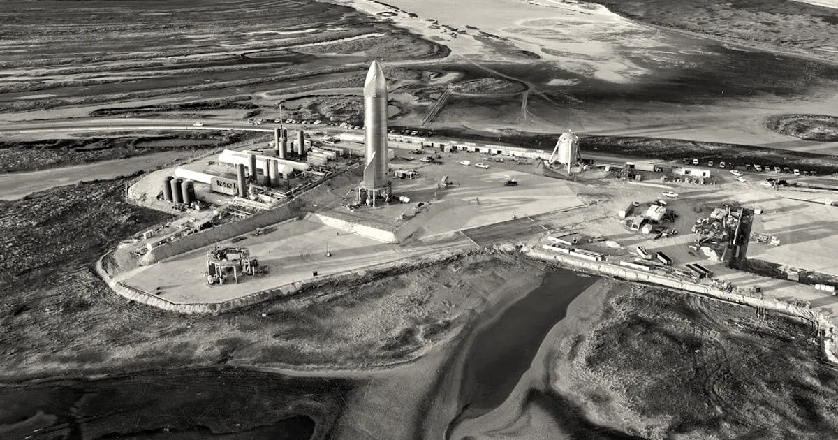 Aerial view of a SpaceX Starship rocket standing on the launchpad at the Boca Chica facility.