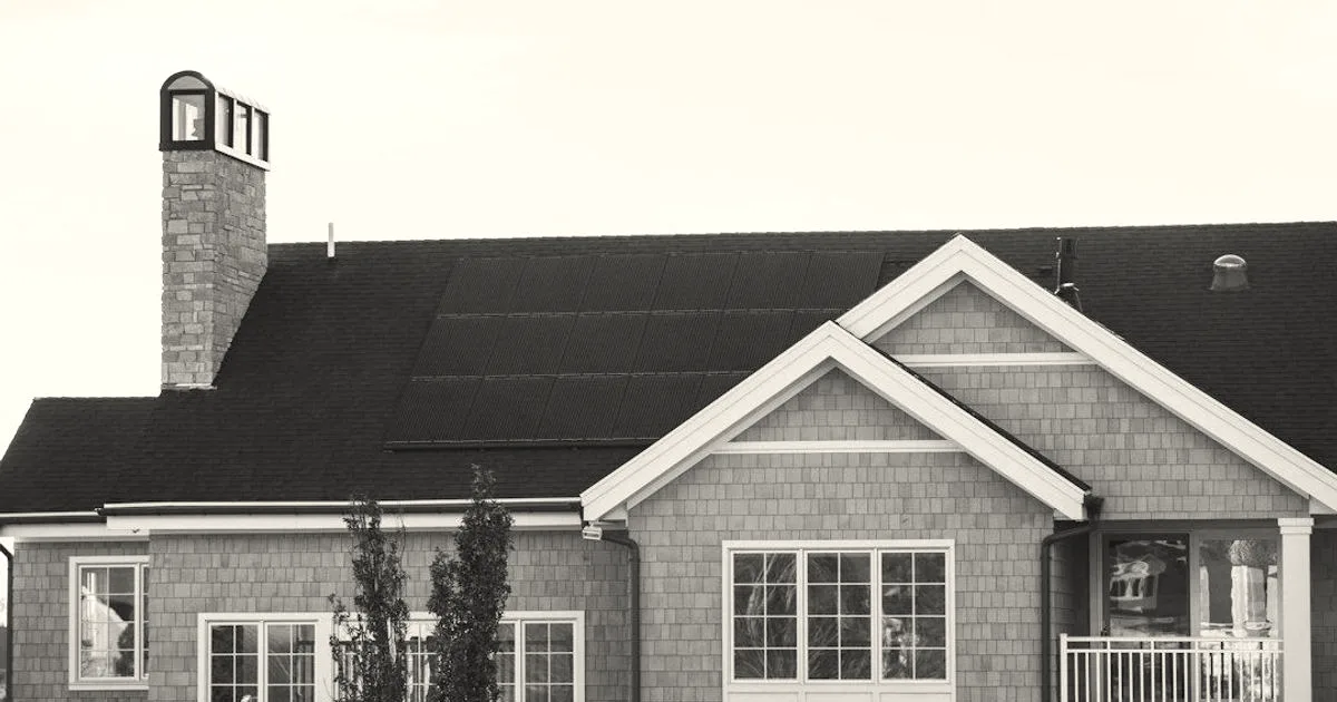 Sleek dark solar panels integrated seamlessly onto the roof of a large modern suburban home