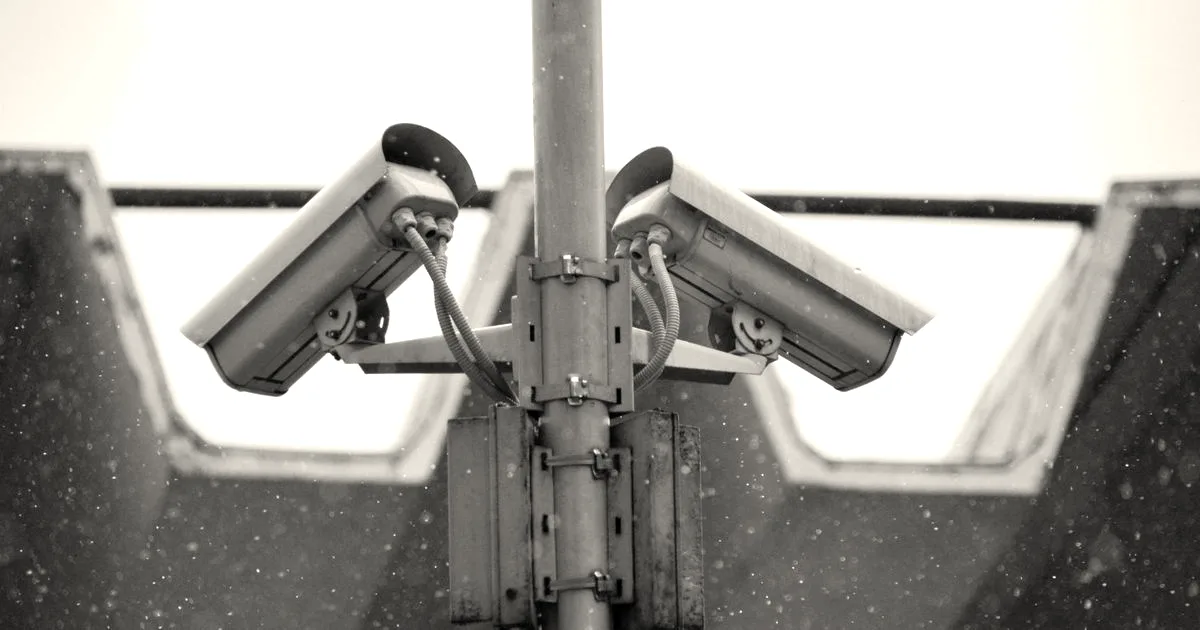 Close-up view of surveillance cameras during a snowfall in urban Москва setting.