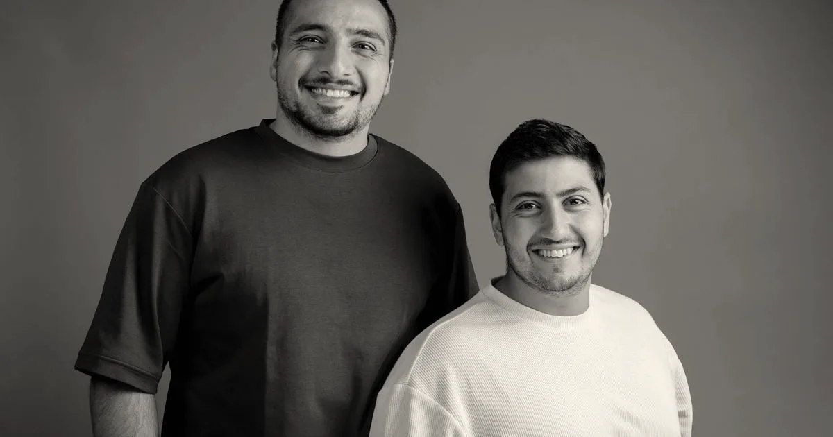 Co-founders of Newlight, CEO Haran Hillel Cohen and COO Evyatar Cohen, standing together smiling against a grey background.