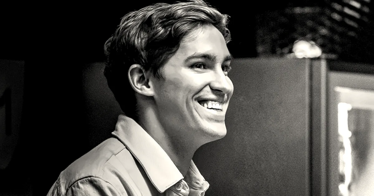 Portrait of ElevenLabs CEO Mati Staniszewski smiling, viewed in profile against a warm interior background.
