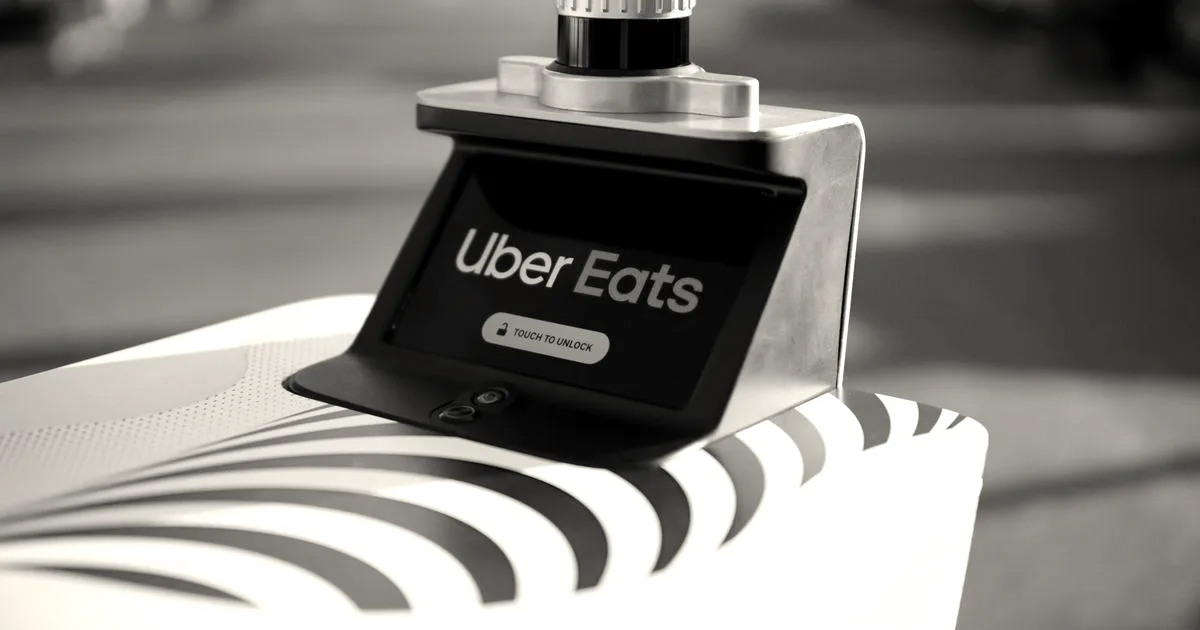 Close-up of a Serve autonomous delivery robot displaying an Uber Eats screen on top.