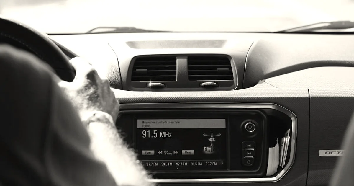 A driver's view of a modern car dashboard featuring a digital touchscreen display radio receiver.