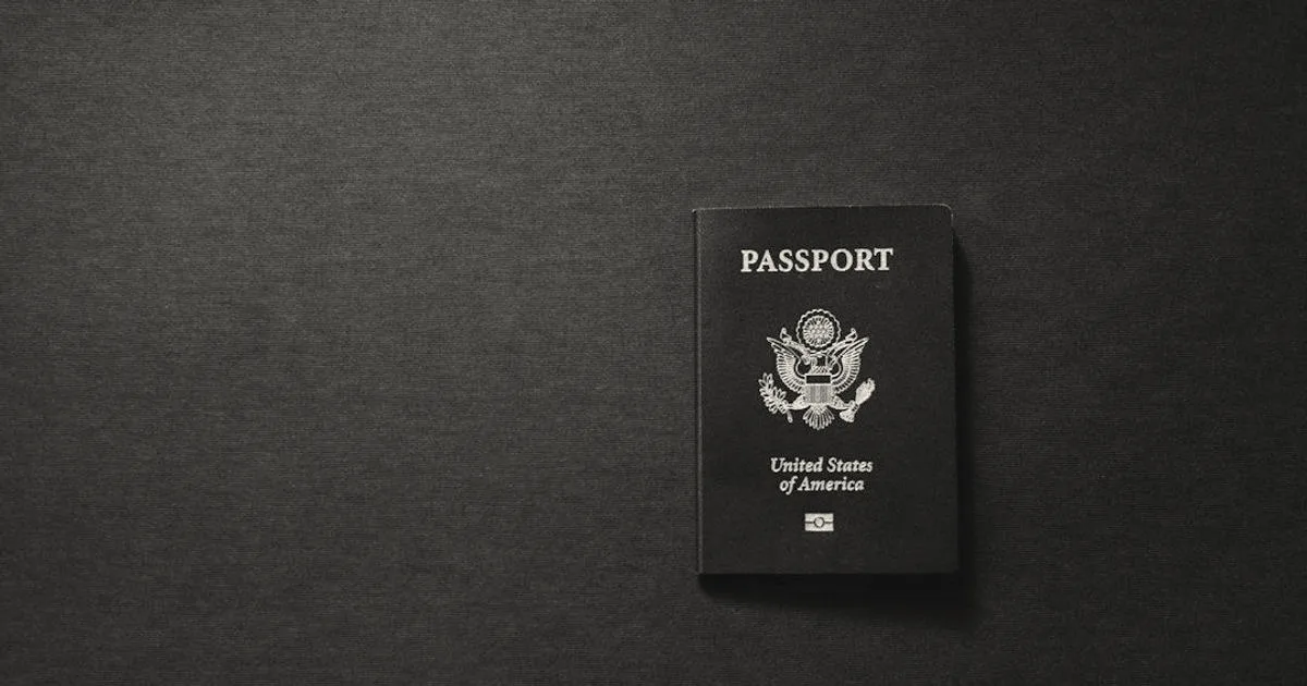 A dark blue United States passport placed on a textured dark gray surface