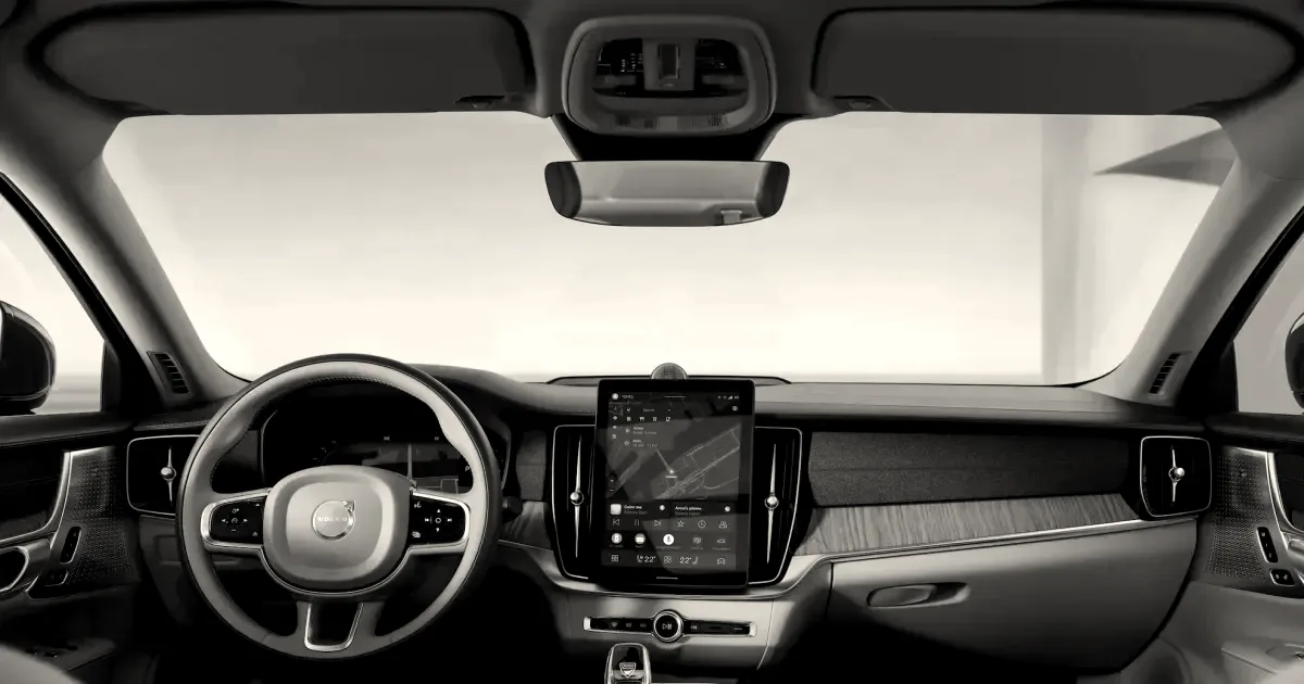 Interior cabin of a Volvo car showcasing the steering wheel and center console infotainment display.